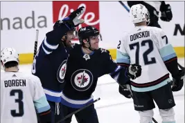  ?? FRED GREENSLADE — THE CANADIAN PRESS VIA AP ?? Winnipeg Jets’ Blake Wheeler (26) celebrates his goal against the Seattle Kraken with Nikolaj Ehlers (27) during the third period of NHL hockey game action in Winnipeg, Manitoba, Sunday.