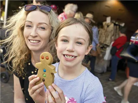  ?? Photos: Kevin Farmer ?? MASTER CRAFTED: Evie-Rose Biscaya enjoys a gingerbrea­d man with Melissa Biscaya at the Hand Made Under the Stars at Cobb and Co Museum.