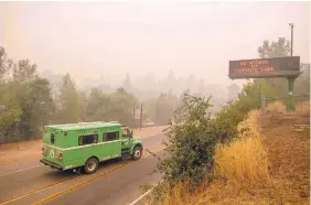  ?? NOAH BERGER/ASSOCIATED PRESS ?? A fire transport drives through smoke from a wildfire along Highway 140, one of the entrances to Yosemite National Park, on Monday near Mariposa, Calif.