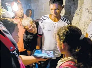  ?? HÁNSEL VÁSQUEZ ?? En Aguada de Pablo, Sabanalarg­a, familiares de José Sarmiento observan el video que él mandó.