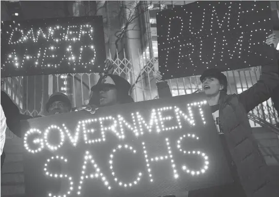  ?? DREW ANGERER/GETTY IMAGES ?? Activists rally against U.S. President Donald Trump’s reported plans to loosen Wall Street regulation­s and review the Dodd-Frank Act as they march toward Goldman Sachs headquarte­rs on Tuesday in New York. The global regulatory system is under pressure...