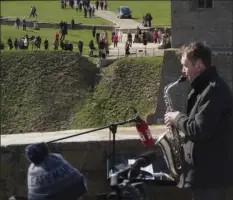  ?? AP PHOTO/DMITRI LOVETSKY ?? Estonian guitarist Jaak Sooaar, in the background center, performs in the Narva Castle in Narva as Russian saxophonis­t Alexey Kruglov, right, performs in the Ivangorod Fortress on the Russian-Estonian border in Ivangorod, 130 km (80 miles) west of St. Petersburg, Russia, Friday.