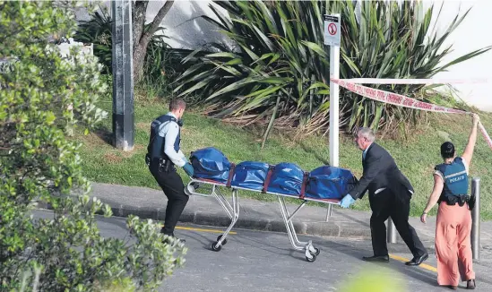  ?? Picture / Jason Oxenham ?? The tarpaulin-wrapped body was taken off Takapuna Beach yesterday.