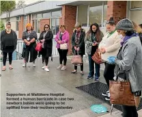  ??  ?? Supporters at Waita¯kere Hospital formed a human barricade in case two newborn babies were going to be uplifted from their mothers yesterday.