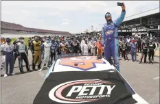  ?? Chris Graythen / Getty Images ?? Bubba Wallace takes a selfie with NASCAR drivers who pushed him to the front of the grid as a sign of solidarity before the GEICO 500 on Monday at Talladega.