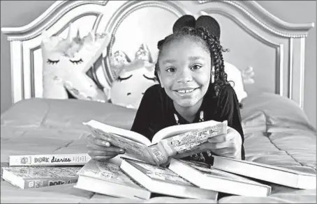  ?? HYOSUB SHIN/ATLANTA JOURNAL-CONSTITUTI­ON ?? Khloe Livsey, 9, is an avid reader of “Dork Diaries,” a popular middle grade series featuring three girls who are white, Black and Latina.