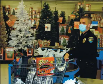  ?? PHOTOS BY BOB MINENNA ?? Clearlake Police Department Police Chief Andrew White enters the checkout line during the annual Shop with a Cop event Monday at Walmart in Clearlake. Law enforcemen­t officers from several jurisdicti­ons are each allowed to spend $200 for toys, clothes and other Christmas gifts that are given to children in need.