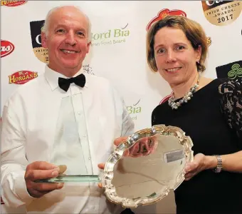  ??  ?? Tom Burgess, winner of the Supreme Champion Award for his Coolattin Cheddar ‘Mount Leinster Clothbound’, is presented with his award by Tara McCarthy from Bord Bia.