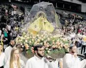  ?? PEDRO PORTAL El Nuevo Herald file, 2016 ?? Catholic parishione­rs observe as members of Encuentros Juveniles from the Miami archdioces­es carry the statue of La Virgen de la Caridad del Cobre (Our Lady of Charity of El Cobre), as the Catholic faithful celebrate the feast of Our Lady of Charity of El Cobre.