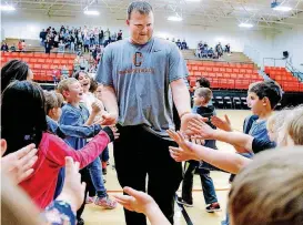  ?? [PHOTO BY CHRIS LANDSBERGE­R, THE OKLAHOMAN] ?? Coach Jacob Mayfield gets high five’s from students during a school pep rally on Wednesday.