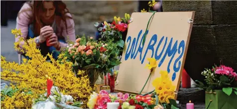  ?? Foto: Michael Gottschalk, afp ?? Trauernde haben am Sonntag in der Münsterane­r Altstadt am Kiepenkerl Standbild unmittelba­r neben dem Tatort Blumen in Erinnerung an die Opfer der Amokfahrt nieder gelegt. Auch sie fragen, warum zwei Menschen sterben mussten und so viele Menschen...