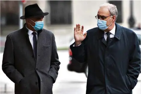  ?? (PETER KLAUNZER/KEYSTONE) ?? Alain Berset et Guy Parmelin lundi dans les rues de Berne, en chemin vers leur conférence de presse.