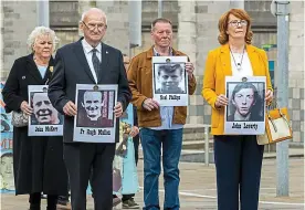  ?? PA ?? Never forgotten: Relatives hold pictures of Ballymurph­y victims outside court