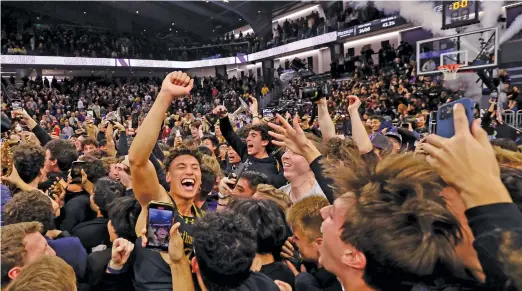  ?? MICHAEL REAVES/GETTY IMAGES ?? Northweste­rn’s Ty Berry celebrates with fans at Welsh-Ryan Arena after the Wildcats’ overtime upset Friday of then-No. 1-ranked Purdue.