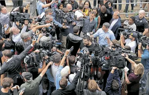  ?? Chip Somodevill­a/Getty Images ?? Matthew Heinbach, center, of the white nationalis­t Traditiona­list Workers Party is surrounded by journalist­s and protesters Monday outside the General District Court building in Charlottes­ville, Va.