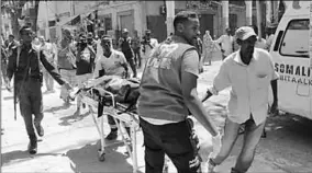  ??  ?? Emergency staff carry the body of a victim at the scene of a car-bomb attack.