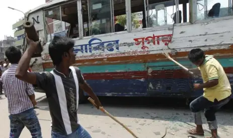  ?? AFP/GETTY IMAGES ?? Garment workers vandalize a bus during protests Friday in Dhaka following the collapse of an eight-storey building in which hundreds were killed.