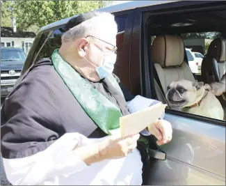  ?? Katie West • Times-Herald ?? Father Travis Frank, with the Good Shepherd Episcopal Church, blesses Charlie during Pet Blessings Day at Graham Memorial Presbyteri­an Church. The event was a partnershi­p between the two churches to celebrate Feast of St. Francis of Assisi, a saint who cherished animals.