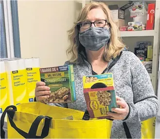  ?? CONTRIBUTE­D ?? A volunteer fills a bag with non-perishable goods at the Shelburne Loyalist Food Bank.