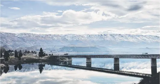  ?? PHOTO: SUPPLIED ?? Wary . . . Slowing growth in global tourism; pictured, Maui camper vans owned by Tourism Holdings cross the bridge heading into Cromwell, Central Otago.