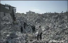  ?? SERGEY PONOMAREV — THE NEW YORK TIMES ?? People search through the rubble of an apartment building after an earthquake that devastated parts of Turkey and Syria in Iskenderun, Turkey, on Sunday.