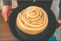  ?? (Courtesy Photo/ Whitney Rutz) ?? Whitney Rutz displays a large cinnamon roll before putting it in the oven in her home in Portland, Ore.