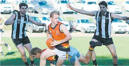  ??  ?? Longwarry’s Kane Oldham looks for a passing option during the match against Poowong. The Crows scored a comfortabl­e victory to continue their challenge for the top five.