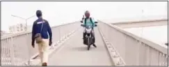  ??  ?? A delivery boy using a pedestrian bridge to cut distance.