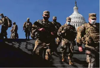  ?? Andrew Harnik / Associated Press ?? National Guard troops walk on Capitol Hill on Thursday with the dome of the Capitol Building in the background. Troops have flooded Washington, D.C., ahead of the presidenti­al inaugurati­on.