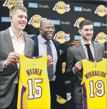  ?? Photograph­s by Christina House Los Angeles Times ?? MAGIC JOHNSON was in the middle of things when the Lakers introduced draft picks Moe Wagner and Svi Mykhailiuk, and Johnson made the big news of the day when he set a deadline for signing free agents.