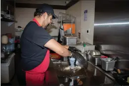  ?? PHOTOS BY GERARDO ZAVALA — DAILY DEMOCRAT ?? Jesse Aldaz, 33, prepares a cheesestea­k Tuesday at He's From Philly Cheesestea­k in downtown Woodland.