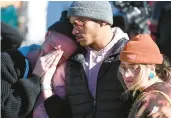  ?? JASON CONNOLLY/GETTY-AFP ?? Tyler Johnston, left, Keenan Mastes-Holmes and Altas Pretzeus pay their respects Sunday at a makeshift memorial in Colorado Springs, Colo., for victims of a mass shooting at a gay nightclub Saturday night.