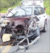  ?? Courtesy photograph ?? Caleb Woods of Pea Ridge was reportedly driving this 2002 GMC, the remnants of which straddle the yellow line after a crash involving a 2008 Jeep on Arkansas Highway 102, east of Decatur, on May 4. The impact between the two vehicles was so violent that the entire front end of the SUV was ripped away from the rest of the vehicle and the engine was deposited in the middle of the highway.