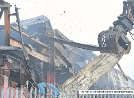  ??  ?? The roof of the Wing Fat store being demolished