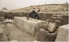  ?? AP ?? An Egyptian antiquitie­s worker cleans a recently unearthed embalming bed at the Saqqara necropolis, south-east of Cairo