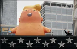  ?? ELIZABETH FLORES/MINNEAPOLI­S STAR TRIBUNE ?? A giant Trump balloon was placed above First Avenue, across from the Target Center, in preparatio­n for President Donald Trump’s visit Thursday in Minneapoli­s, Minn.