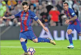  ??  ?? Barcelona's Argentinia­n forward Lionel Messi kicks to score a penalty during the Spanish league football match against SD Eibar at the Camp Nou stadium in Barcelona on Sunday.