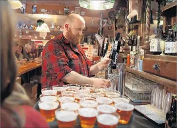  ?? Justin Sullivan Getty Images ?? TIM DECKER pours beer samples at Lagunitas Brewing Co. in Petaluma, Calif., in 2014. Lagunitas is known for its India pale ale style of beer, one of the fastest-growing categories in the craft-beer segment.