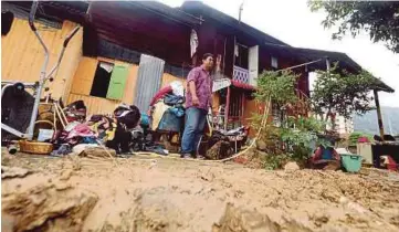  ?? PIC BY DANIAL SAAD ?? Hamir Rudin clearing the mess at his home in Kampung Masjid in Air Itam yesterday.