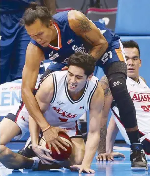  ?? JOEY MENDOZA ?? Meralco’s Reynel Hugnatan and Alaska’s Chris Banchero both have a hand in the leather in a mad scramble for possession.