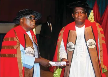  ??  ?? A Professor of History, Osun State University, Osogbo, Siyan Oyeweso (right) being conferred with the fellowship of the Nigerian Academy of Letters by the President, Professor Olu Obafemi, during the 19th convocatio­n and investitur­e of fellows held at...