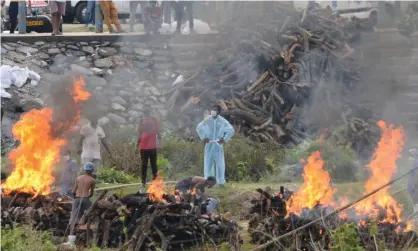  ?? Photograph: AFP/Getty Images ?? Workers cremate people who have died of Covid-19 at a crematoriu­m outside Siliguri on Tuesday. Epidemiolo­gists believe the country’s reported death toll is only a fraction of the true figure.