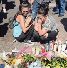  ?? ROBERT HANASHIRO, USA TODAY NETWORK ?? Crystal Fernandez, left, and Carmen Arias pause at a memorial near Las Vegas’ Mandalay Bay hotel.