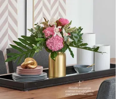  ??  ?? Metallic accents on a mirror tray add glitz to your warm timber table.