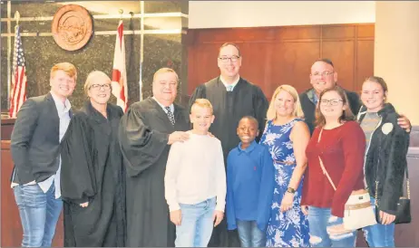  ?? — The Washington Post photo courtesy of the Blairs ?? Ronnie was adopted by the Blairs on Nov 25, 2019. Shown are Hunter Blair, back row from left, with judges of the 13th Judicial Circuit Court of Florida Caroline Tesche Arkin, Ronald Ficarrotta and Thomas Palermo, with Mike Blair. In front are PJ, from left, Ronnie, Danyel, Brittney and Madison.