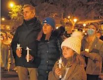  ?? PHOTO: PHOTO: LINDA ROBERTSON ?? Dennis, Olga and Naomi (9) Pushenko, who are all of Ukrainian descent, take part in a candleligh­t vigil for Ukraine in Dunedin’s Octagon last month.