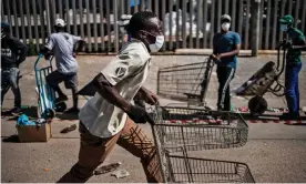  ??  ?? Porters queue to help residents of the Olievenhou­tbosch township carry food parcels. Photograph: Marco Longari/AFP via Getty Images