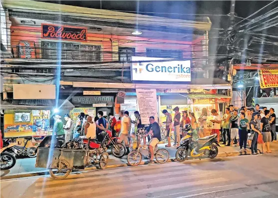  ?? MACKY LIM ?? P1 BILLION. Dozens of residents in Barangay Ubalde, Agdao, Davao City troop to this lotto outlet along R. Castillo Street to place their bets for the Ultra Lotto 6/58 9 p.m. draw that stakes over P1 billion jackpot prize.