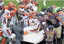  ?? Al Drago, The Associated Press ?? Concerned players surround Bengals quarterbac­k Joe Burrow as he is carted away with a knee injury Sunday in Landover, Md.