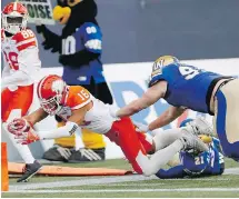 ?? CP ?? B.C. Lions’ Bryan Burnham dives in for the touchdown against Winnipeg’s Jake Thomas and Brandon Alexander (21).